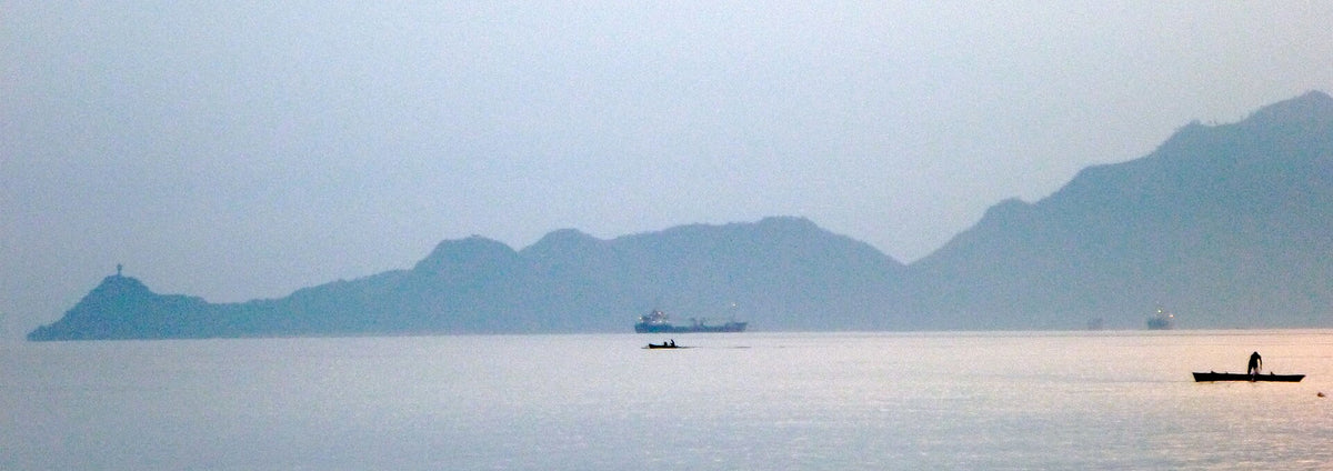 Boats and mountain silhouettes in Dili bay at dawn