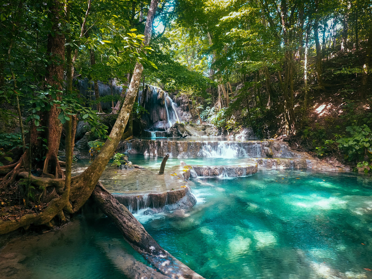 Mata Jitu waterfall and turquoise pools surrounded by forest on Moyo Island, Indonesia