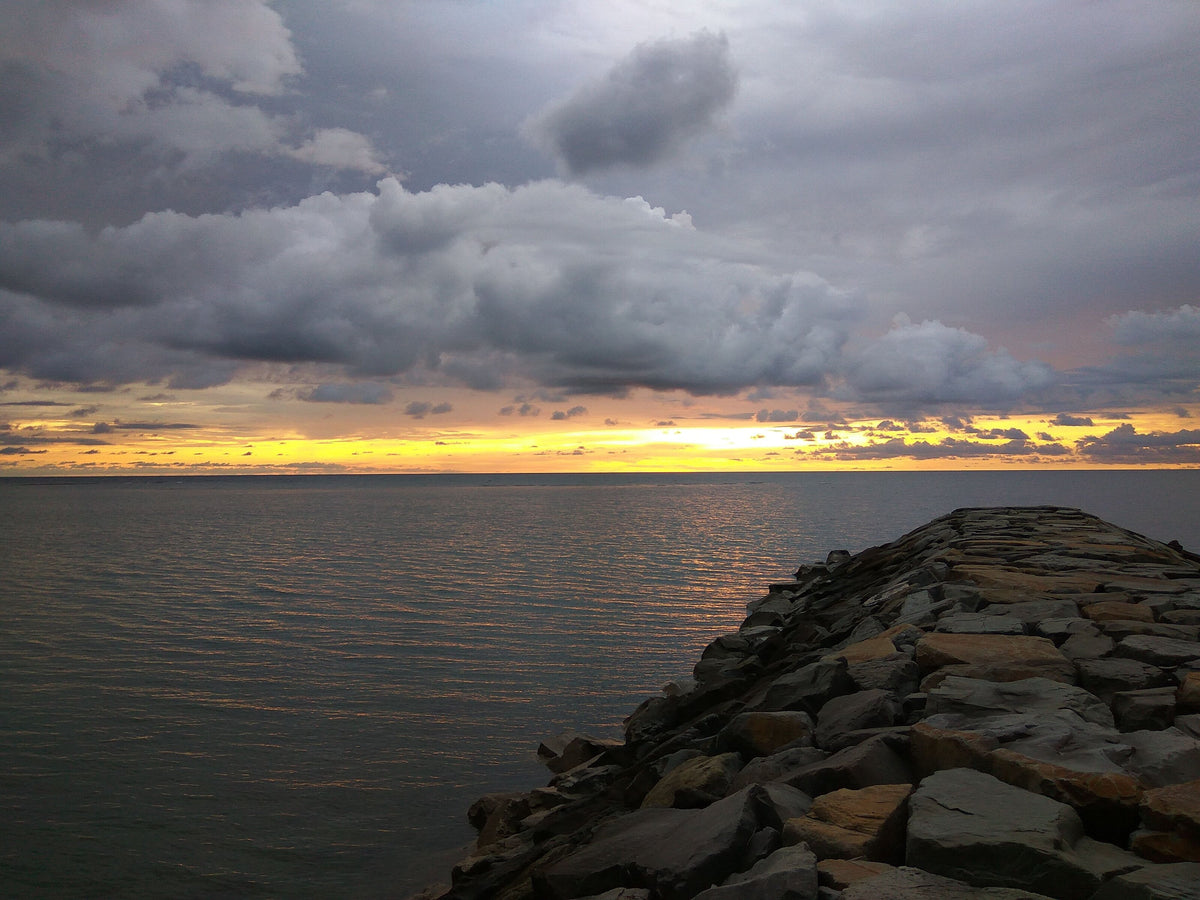 Sunset beneath dramatic clouds over the coast of Labuan, Malaysia