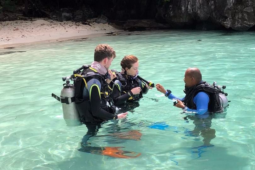 Palawan Divers instructor and students preparing for a dive in shallow water