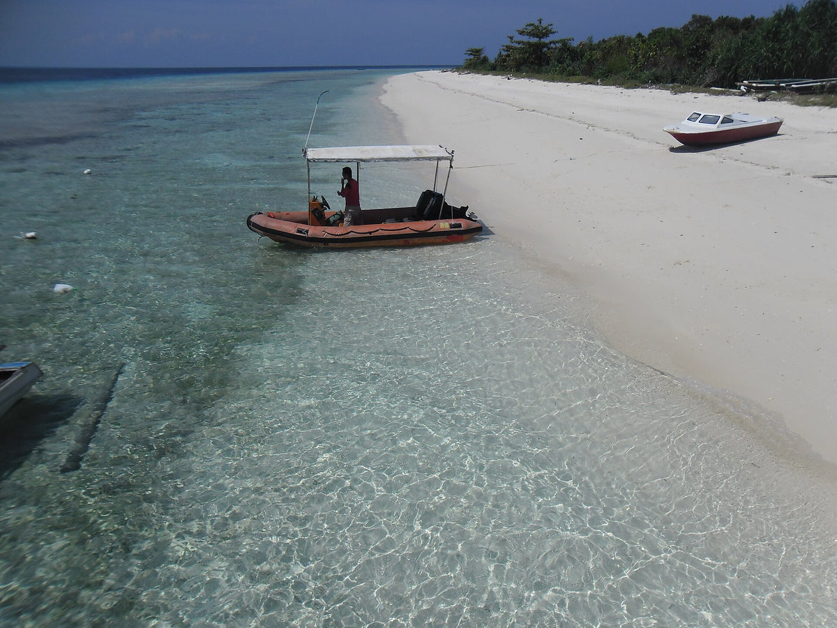 White sand, small boats and shallow water at Turtle Beach, Pom Pom Island