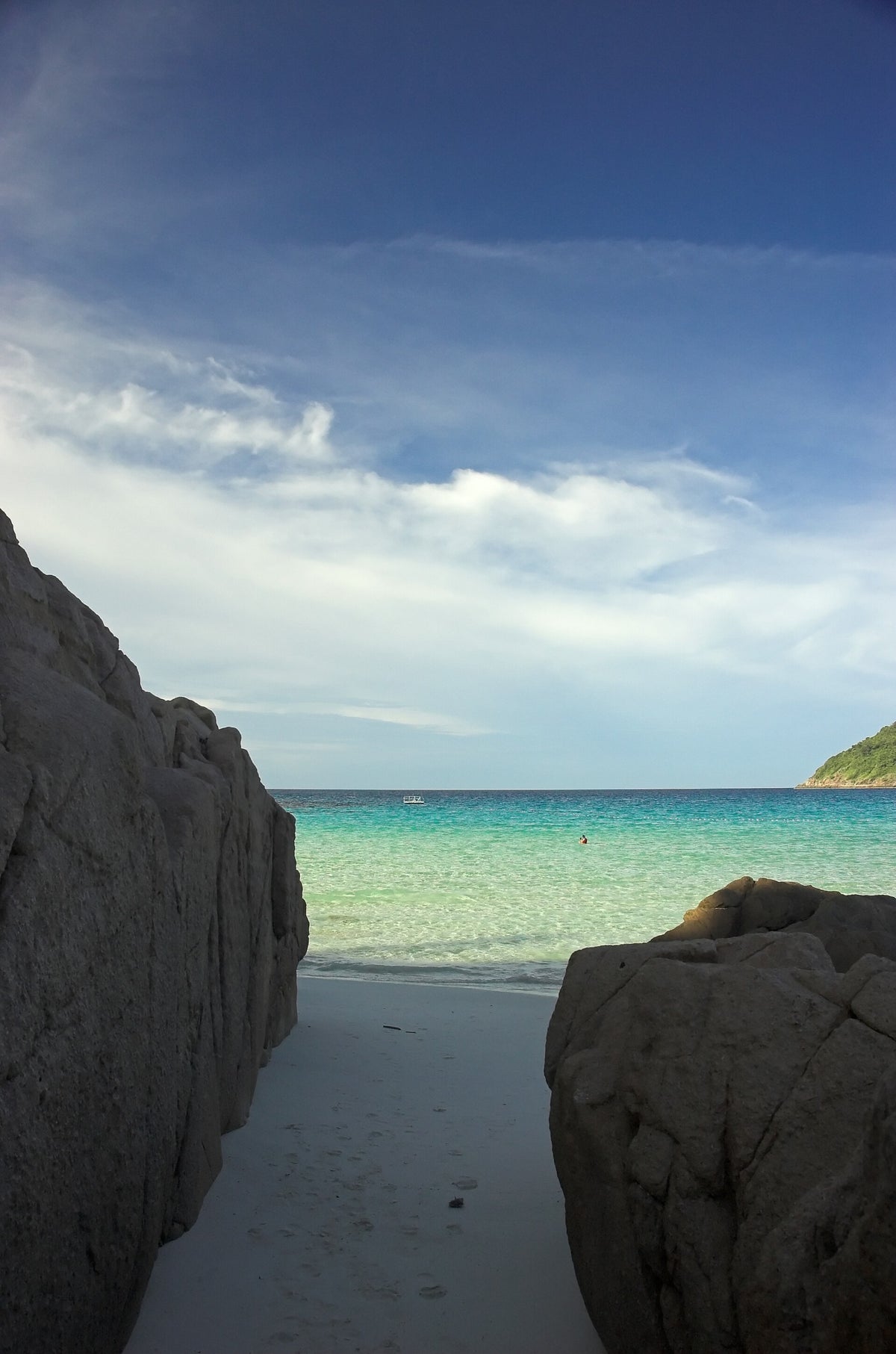 Turquoise sea seen between coastal boulders on Redang Island