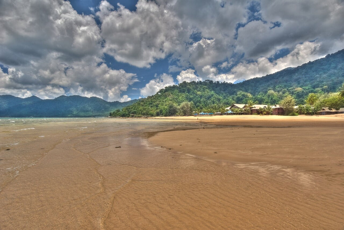Broad sandy beach and forested hills on Tioman Island