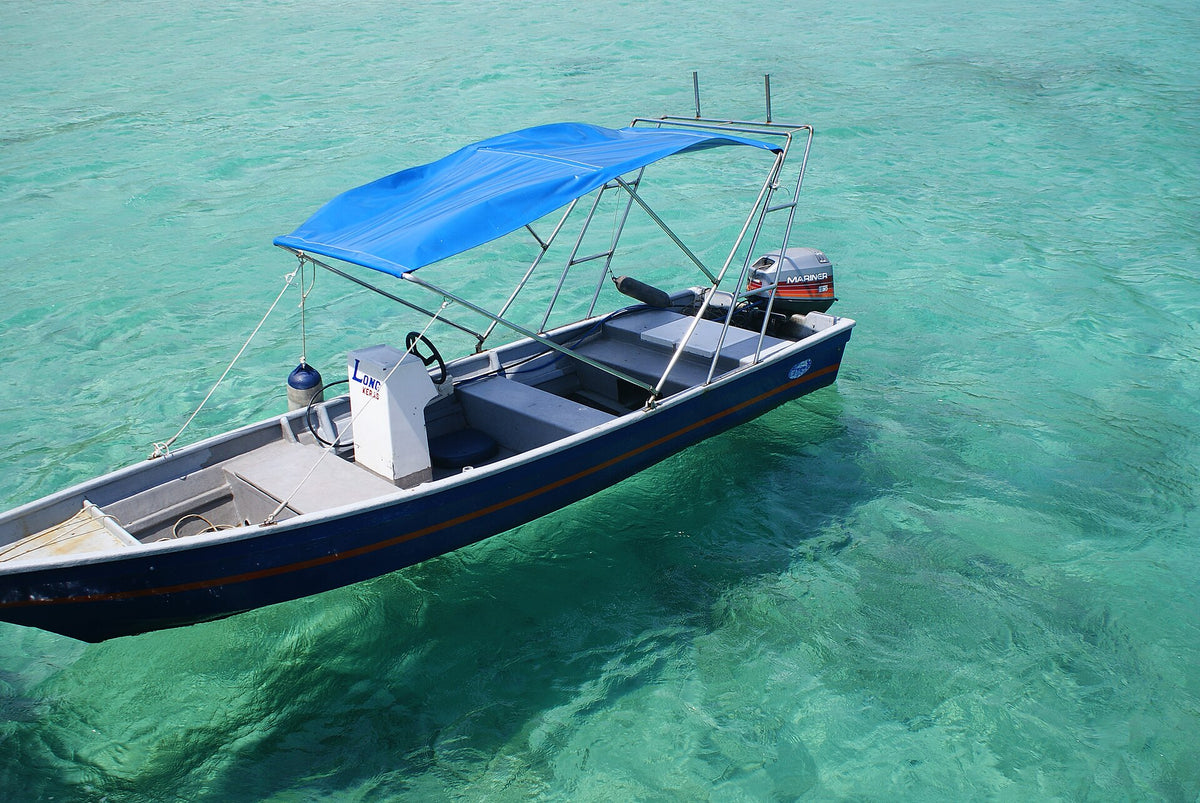 Boat floating above clear turquoise water at Salang, Tioman Island
